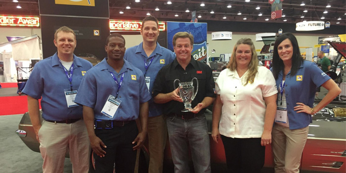 Members of the BASF Automotive Refinish team accepting the Top Custom Car Award with Chip Foose. From left to right: Justin Griffin, BASF sales development intern; Marcus Grant, BASF sales development intern; Steve Shemanski, BASF customer care representative; Chip Foose; Tina Nelles, BASF marketing services manager and Kate Kalahar, BASF customer care representative.